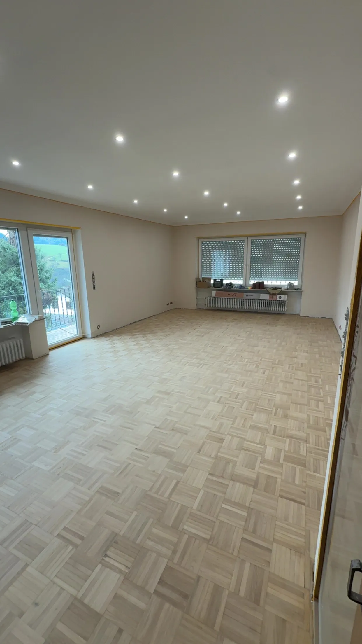 Renovierter Wohnraum mit geschliffenem Parkett und Deckenspots
